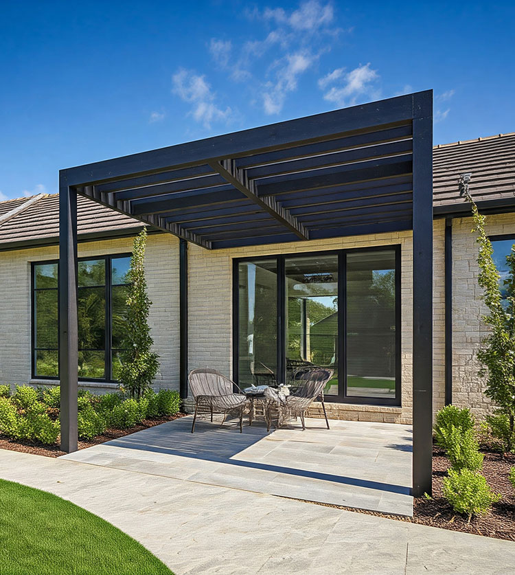 Modern black pergola over concrete patio with seating, attached to contemporary brick home