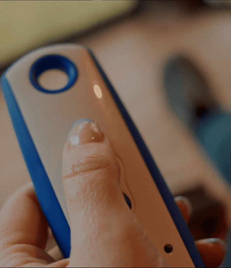 Hand holding white and blue motorized screen remote control