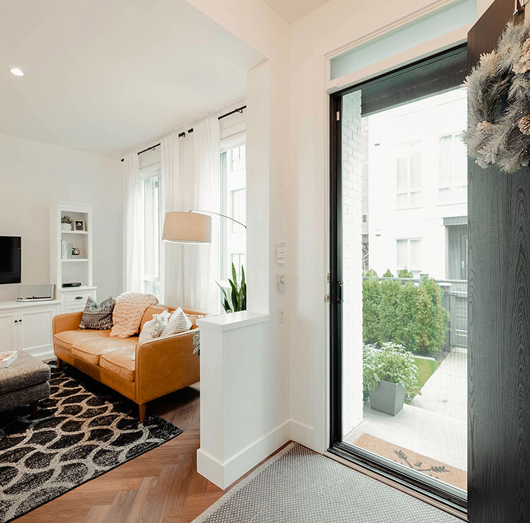 Modern home entry with a black front door and nearly invisible retractable screen across the open doorway.