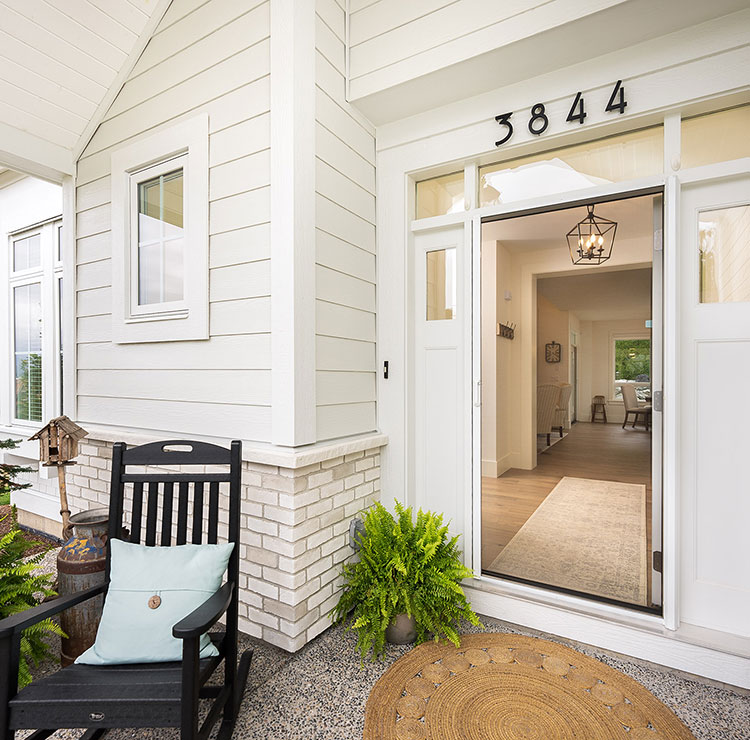 Bright front porch with a white entry door and a fully extended retractable screen subtly enclosing the doorway.