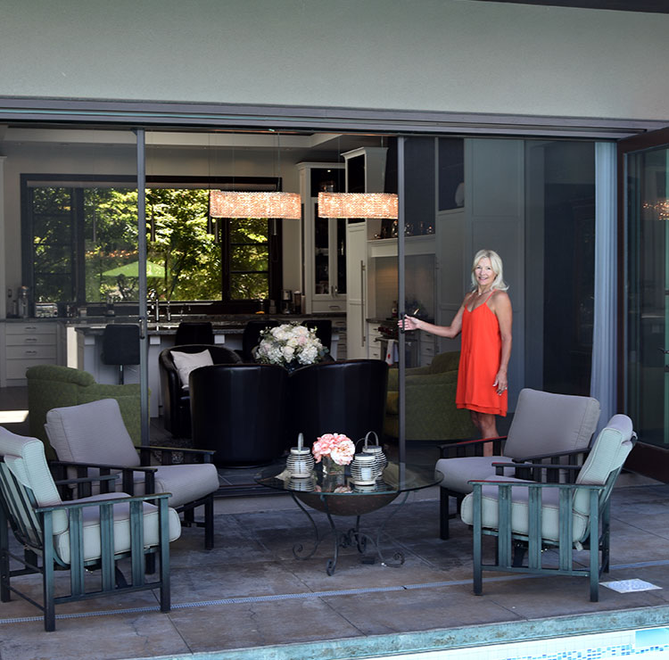 Covered patio with retractable screens, modern outdoor furniture, and decorative lanterns around seating area