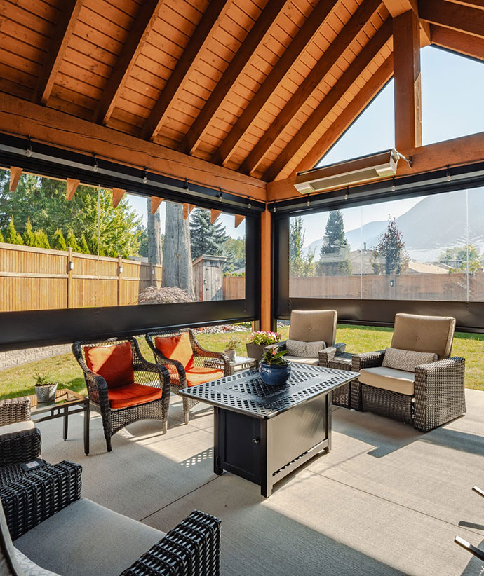 Covered patio with retractable screens and clear vinyl panels creating a comfortable outdoor living space with modern furniture