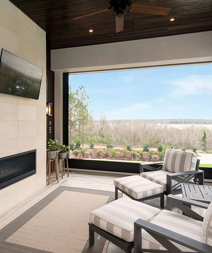 Contemporary covered patio with retractable screens featuring a gas fireplace and comfortable seating area