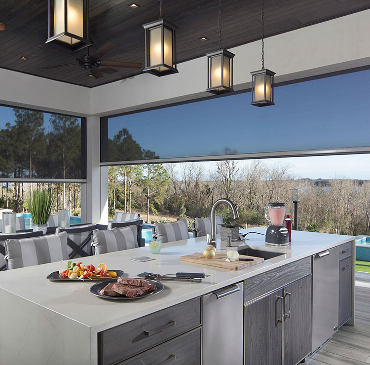 Luxury outdoor kitchen with retractable screens, overlooking pool and scenic water view