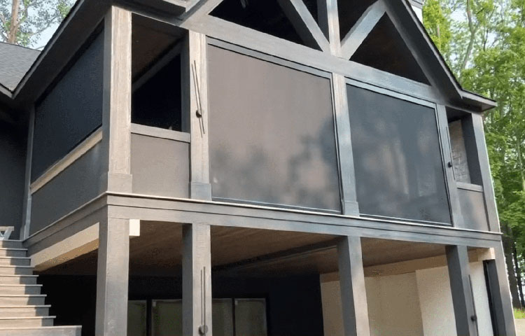 Gray two-story home with retractable screens on the covered upper balcony