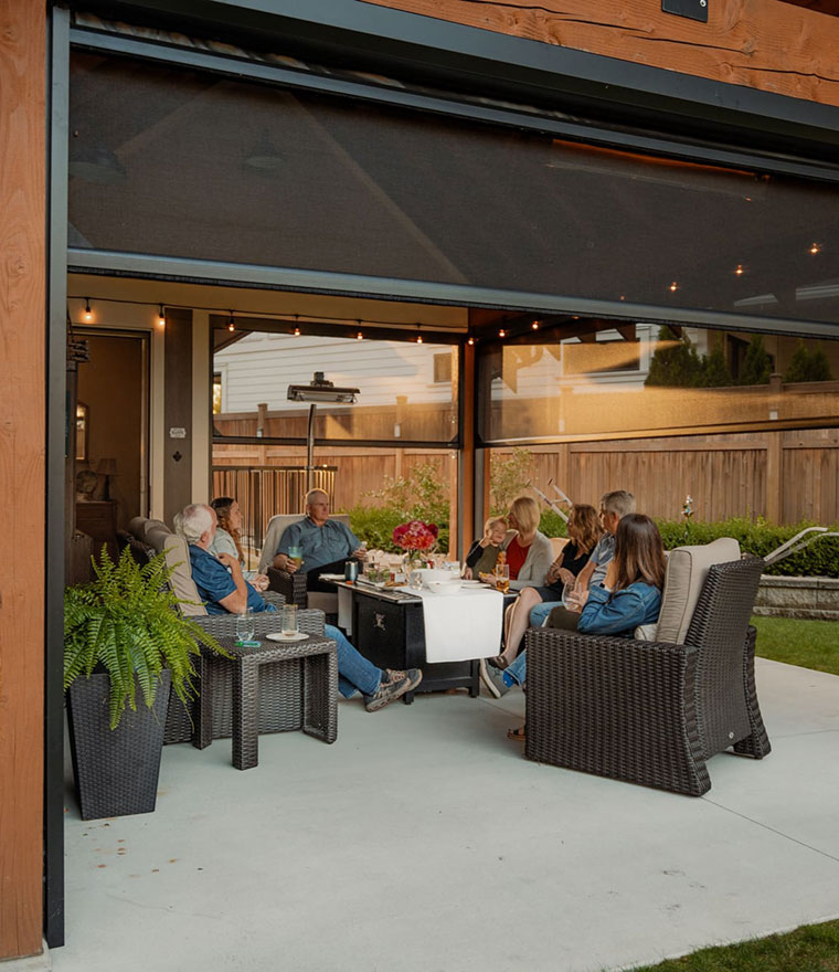 Family gathered on covered patio with motorized retractable screen