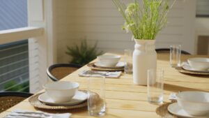 A neatly arranged table set with white plates and cups