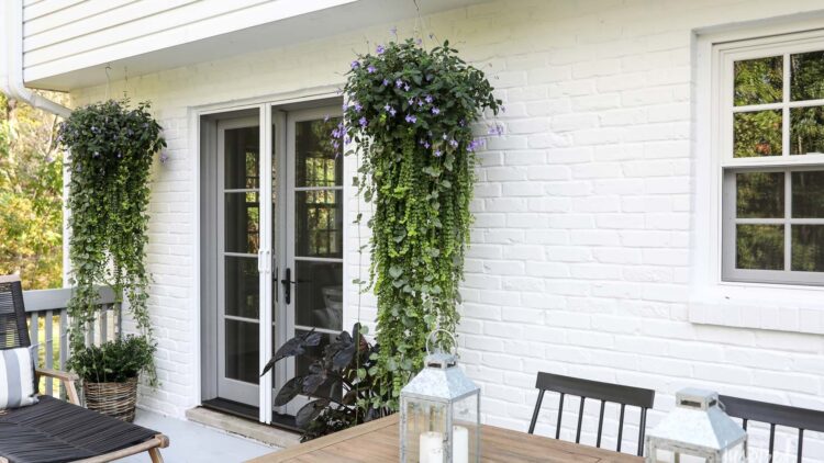 A patio featuring white walls, furnished with a table and chairs, creating a cozy outdoor dining space.