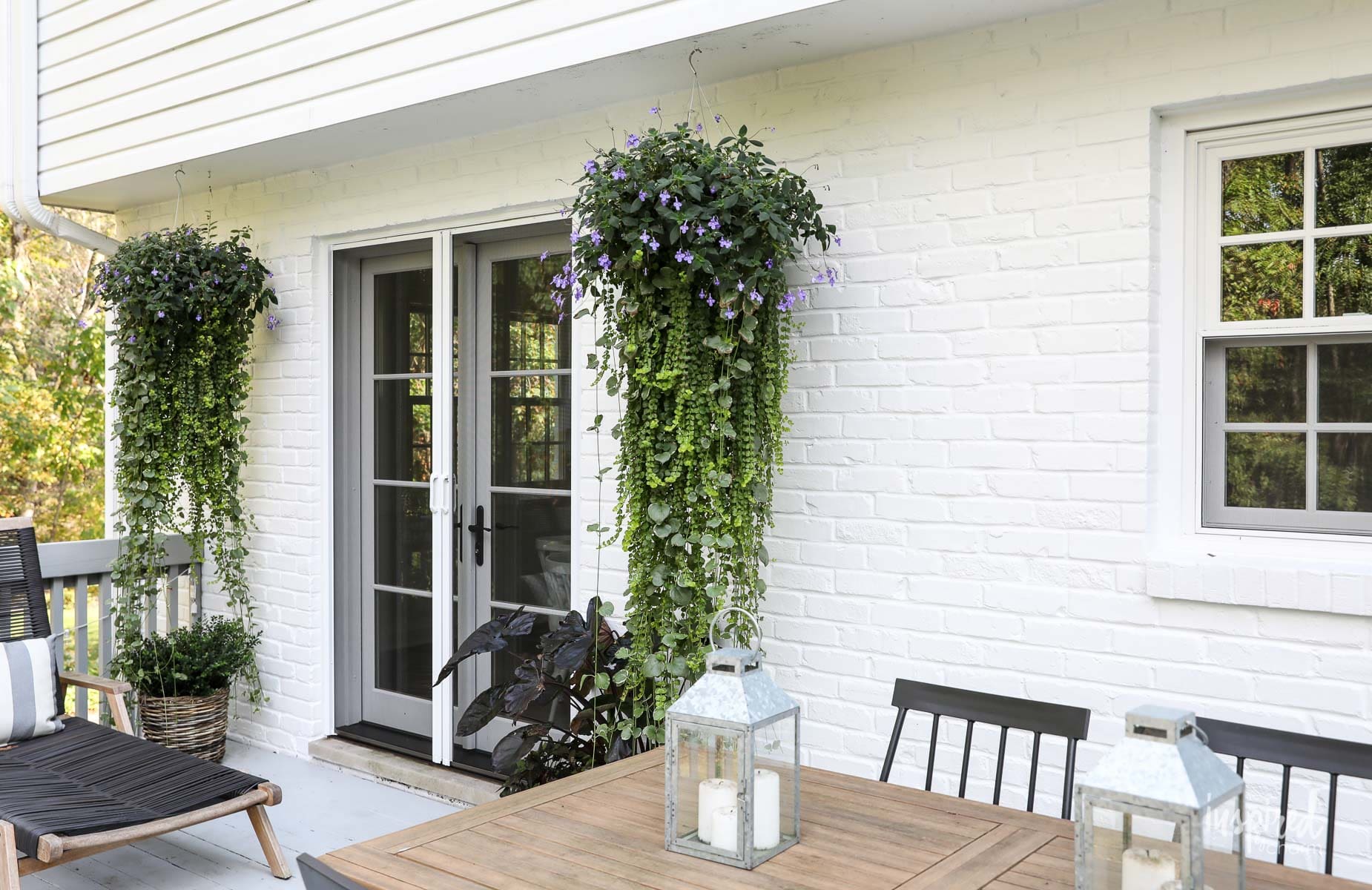 A patio featuring white walls, furnished with a table and chairs, creating a cozy outdoor dining space.